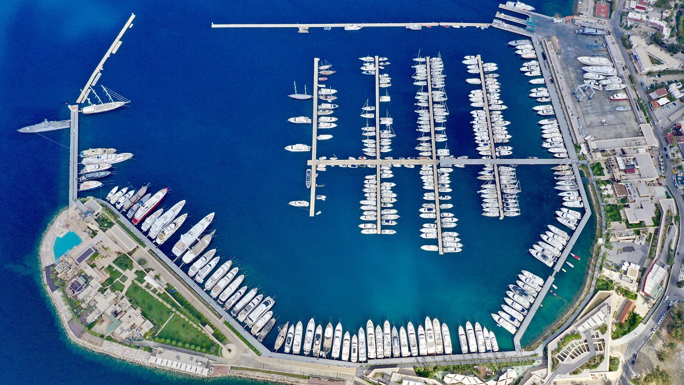 MARİNANIN BİNASI SOĞUK, İNSANI SICAK/ Her ne kadar yeşillendirmeye çalışıldıysa da marinadaki kullanılan malzemelerden kaynaklanan sert görünüme karşın görevli insanların güler yüzlü olması ve işlerini yaparken her yerlerinden uzmanlık fışkırırken aynı anda size arkadaşınız gibi yaklaşmaları hemen göze çarpıyor. (Fotoğraf: Bodrum Yalıkavak Marina)