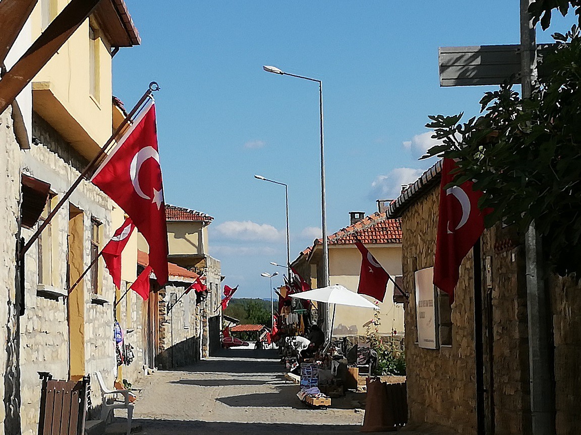 BAYRAKLAR TÜRKİYE’NİN HER YERİNDEN GELİYORBu köyün tüm evleri yaz-kış, 365 gün 24 saat bayraklı. Ve doğusundan batısına kadar Türkiye’nin tüm şehirlerinden buraya bayrak yağıyor. Gelenler, bilenler, duyanlar kargoları bayrakla dolduruyor, köye gönderiyorlar. Askeriye de bu konuda çok hassas. Bayraklar daima temiz ve asılı kalacak diye hep birlikte özeniliyor.