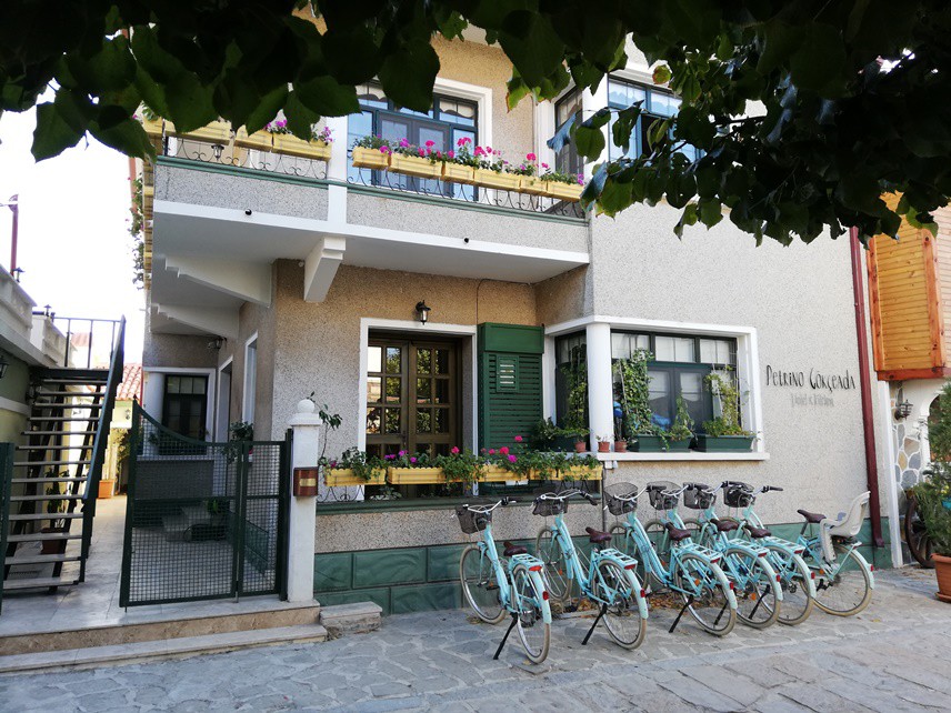 ASMA YAPRAKLARI VE BİSİKLET
Bu taş duvarlı, eski ama bakımla şirin otel; kapısına bağlı bisikletlerle adanın en tipik fotoğrafını veriyor.